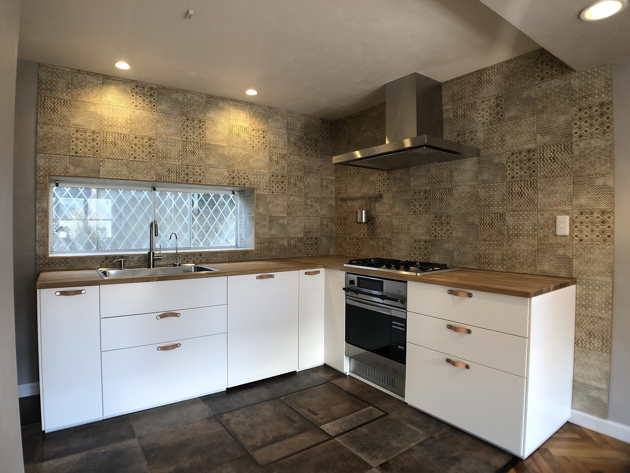 白のIKEAキッチンと革の取っ手